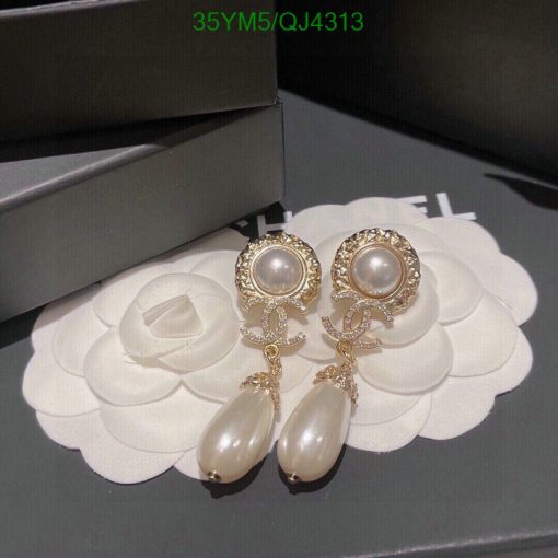 Elegant pearl drop earrings on white floral display.