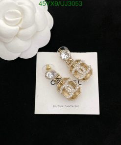 Gold chandelier earrings with crystals on white display.