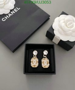 Chanel earrings and packaging on gray background.