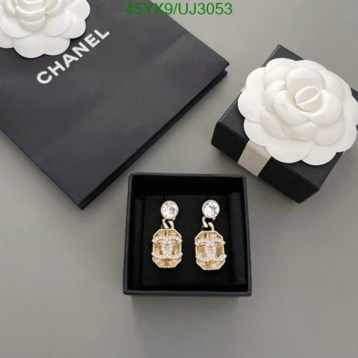 Chanel earrings and packaging on gray background.