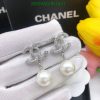 Pearl earrings with silver design on white display.