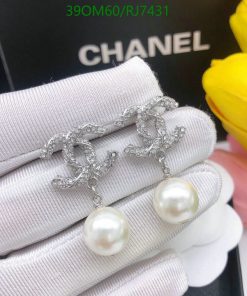 Pearl earrings with silver design on white display.