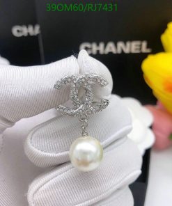 Elegant pearl pendant with sparkling design on white glove.