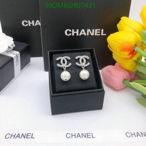 Designer pearl earrings display with flowers and packaging.