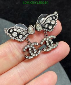 Vintage style rhinestone embellished earrings held in hand.