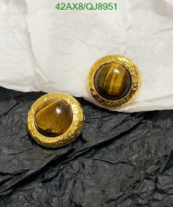 Gold tiger's eye gemstone earrings on contrasting paper.