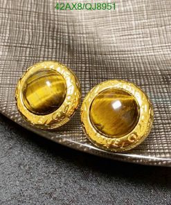 Gold cufflinks on textured fabric.