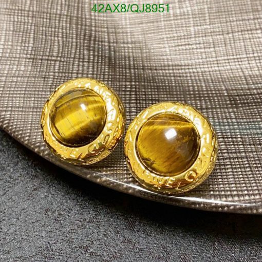 Gold cufflinks on textured fabric.