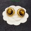 Gold tiger's eye cufflinks on fabric.