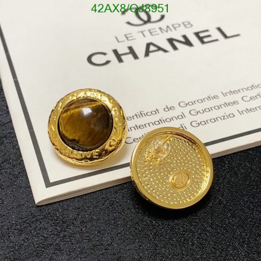 Gold designer button earrings on certificate background.