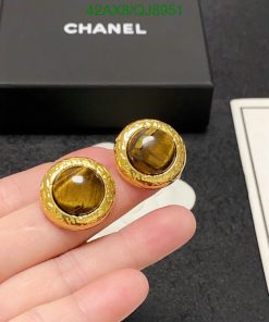 Gold-tone earrings with tiger's eye stones, branded box background.