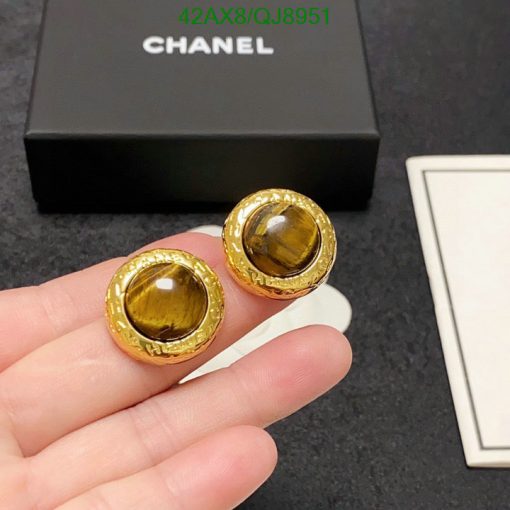 Gold-tone earrings with tiger's eye stones, branded box background.