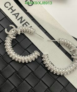 Chanel crystal hoop earrings on quilted surface