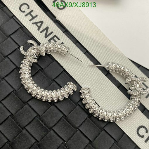 Chanel crystal hoop earrings on quilted surface