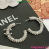 Diamond-encrusted Chanel logo earrings on display.