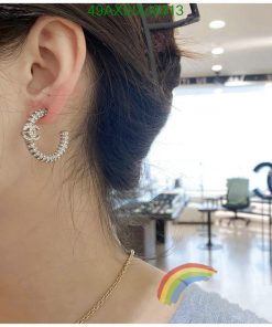 Woman's ear with sparkling crescent earring.