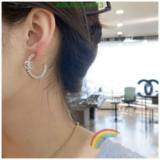 Woman's ear with sparkling crescent earring.