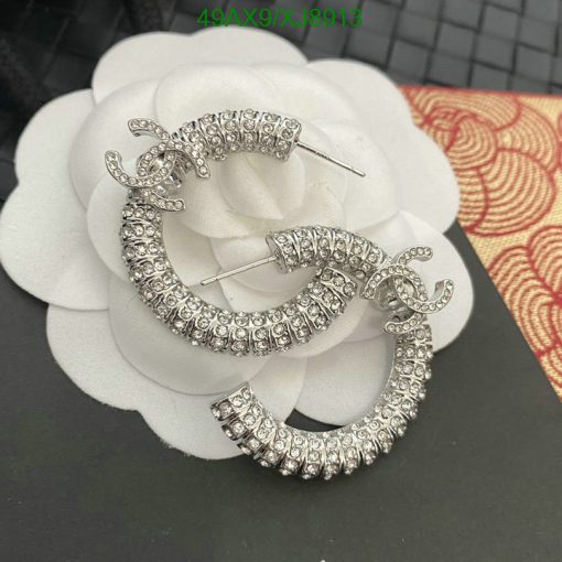 Sparkling hoop earrings with diamond-like stones on white flower.