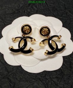 Black and gold designer earrings on white petal-like background.