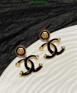 Elegant black and gold designer earrings on textured background.