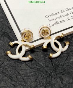 Designer gold and white earrings on certificate background.