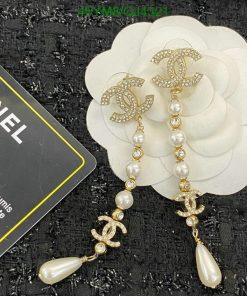 Pearl and rhinestone designer dangle earrings on white flower.