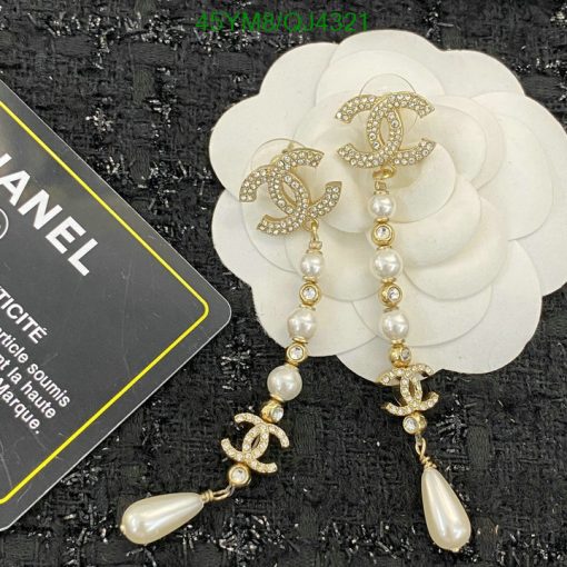 Pearl and rhinestone designer dangle earrings on white flower.