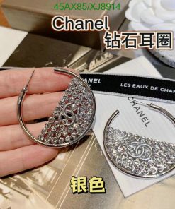 Hand holding Chanel crystal hoop earrings.