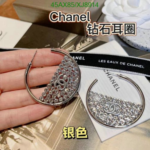 Hand holding Chanel crystal hoop earrings.