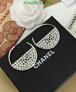 Chanel branded silver rhinestone hoop earrings on display.