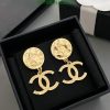 Gold designer logo earrings in box.