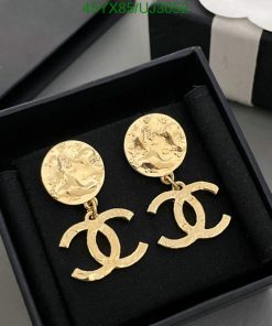 Gold designer logo earrings in box.