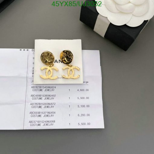 Gold-tone branded earrings on invoice beside jewelry box.