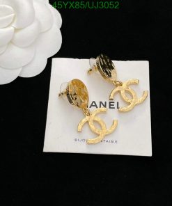 Gold designer logo earrings on white display.