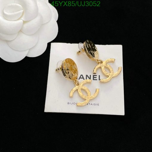 Gold designer logo earrings on white display.