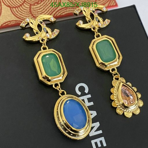 Gold designer earrings with colored gemstones on display.