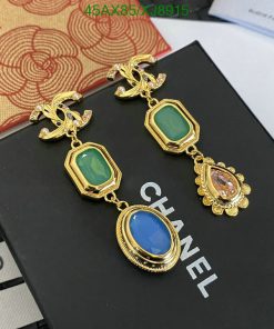 Gold Chanel earrings with colored gemstones on display