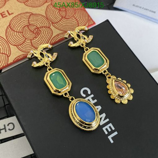 Gold Chanel earrings with colored gemstones on display