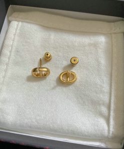 Gold cufflinks on white cloth inside box.