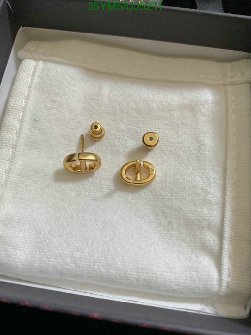 Gold cufflinks on white cloth inside box.