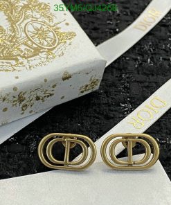 Designer gold-tone shoe buckles on branded packaging.