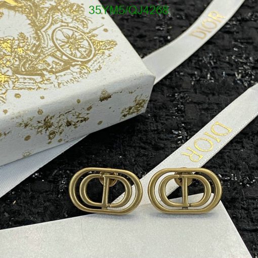 Designer gold-tone shoe buckles on branded packaging.