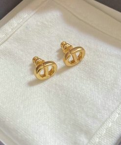 Gold designer cufflinks on white fabric.