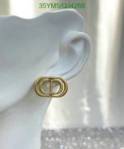 Gold buckle-style earring on mannequin ear.