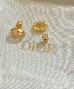 Gold Dior logo cufflinks on white background.