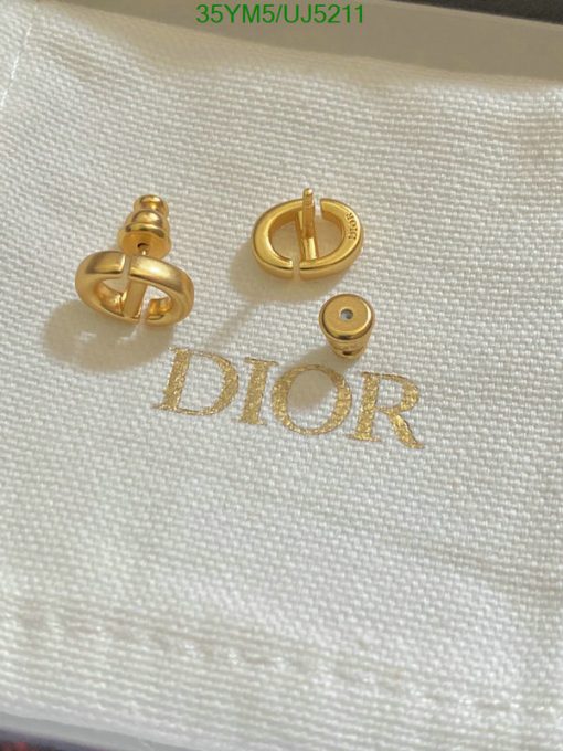 Gold Dior logo cufflinks on white background.