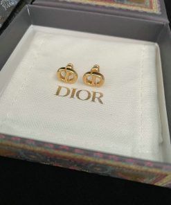 Gold designer logo earrings in branded box.