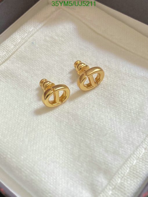 Gold designer cufflinks on white fabric.