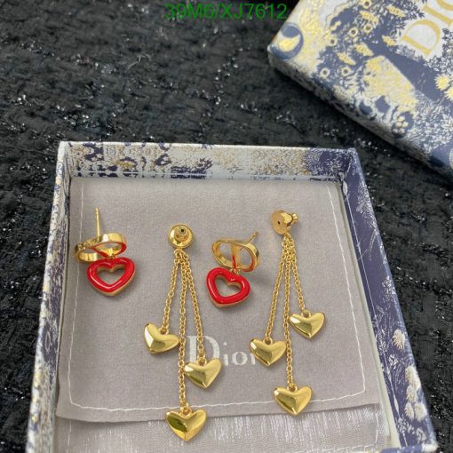 Heart-shaped gold earrings on display box.