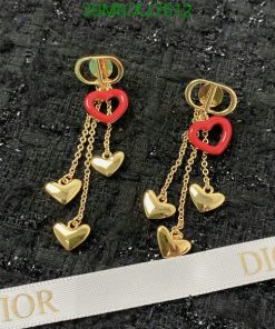 Gold heart-shaped Dior earrings on black textured background.